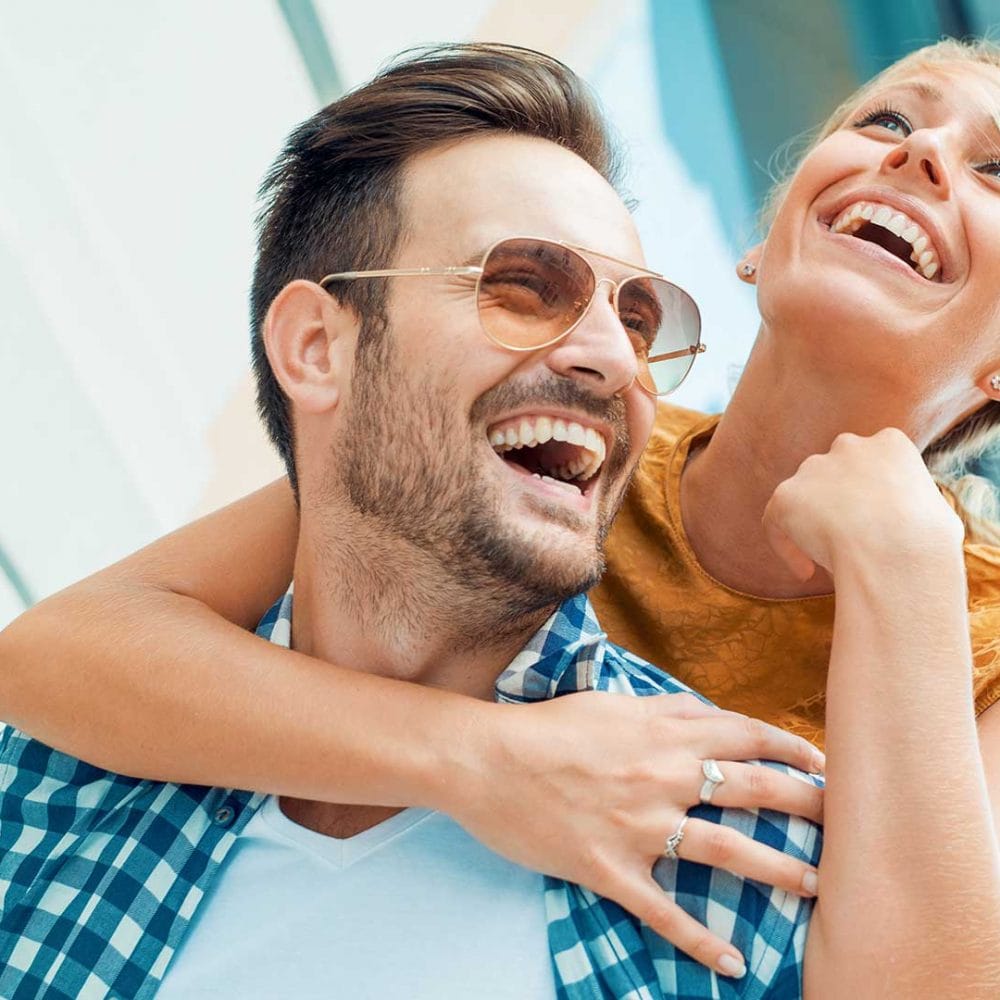 Couple smiling together & looking joyful.